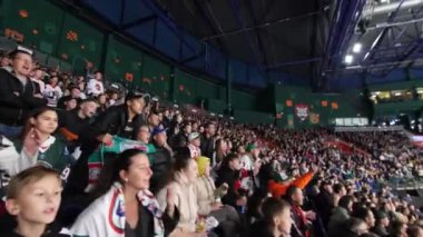 ALMATY, KAZAKHSTAN - 27 Mart 2023: gol atlama ve favori takım için tezahürat beklentisiyle spor taraftarları. Sadık hokey hayranları, buz sahasında oturmuş cesaret verici sözler söyleyen oyuncuları destekliyor.