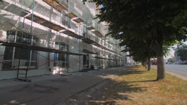 Şehir caddesinin aşağısındaki eski binaların yakınındaki iskeleler. Kasaba bloğundaki kamu merkezinin yenilenmesi