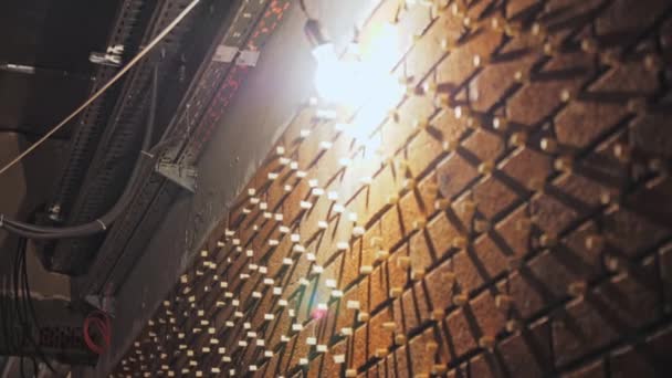 黄色い電球は公共の建物の新鮮な煉瓦の壁を照らします 天井から掛かるワイヤーが付いているロフト様式の部屋で提供される赤外線の仕事 — ストック動画