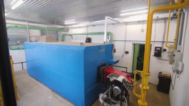 ALMATY, KAZAKHSTAN - Şubat 06 2023: Karmaşık tahıl ambarlarının kurutulması için su tedarik sistemi. Blok siloları için sıcak su kazanlarının üzerindeki sarı borular ve valfler