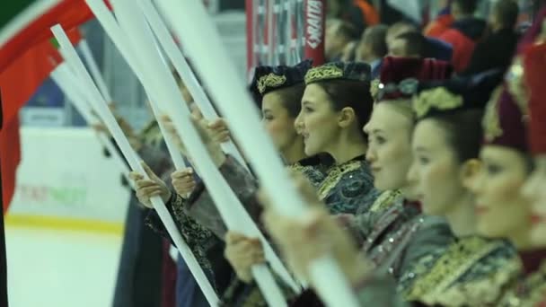 アルマニー カザフスタン July 2023 伝統的な民俗衣装の女性は ホッケーの試合で異なる国を代表する旗を保持しています スポーツトーナメント開始 — ストック動画