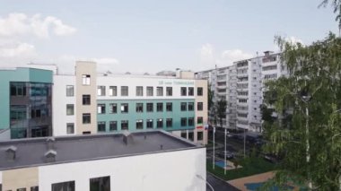 Çocuk parkı olan modern okul binası yerleşim bölgesinde. Çocuk bahçeli şehir lisesi hava manzaralı