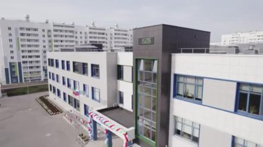 Büyük pencereleri ve beyaz panelleri olan yeni bina kompleksi. Modern tesisin hava manzarasının büyük açılışı.