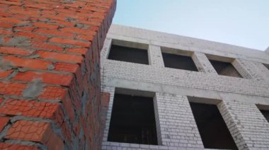 İnşaat mühendisliğinde penceresi olmayan bir bina. İnşaat alanında kırmızı tuğla yapının kapatılması sürüyor