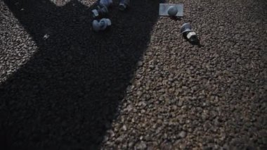 Taze asfalt kaplamasına saçılmış fındıklara vida takın. İnşaat alanında asfalt yolda oruç tutma araçları