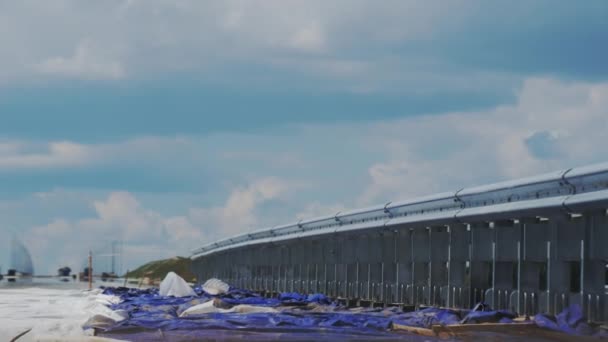 建筑工地修路时的金属栅栏屏障 多云的天空下 在未完成的公路上分隔围栏的交通线 — 图库视频影像