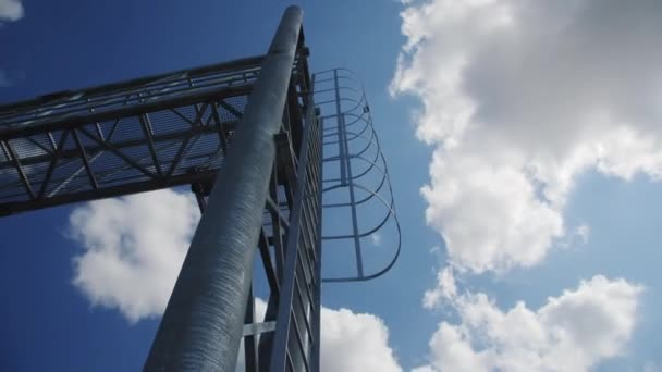 フィールドの田舎道上のボックストラスススパン構造上の梯子にアクセスします 曇りの空の下の田舎に取付けられている印のための頭上構造 — ストック動画