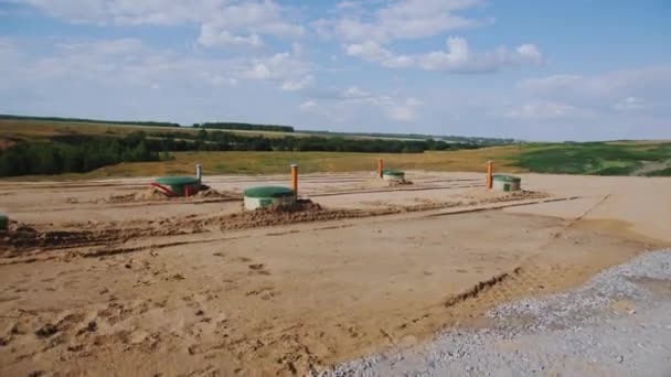 田舎の田舎で掘られたパイプ付きのシスター 夏の田舎で地下に保管する材料のためのタンク インダストリアルシーン — ストック動画