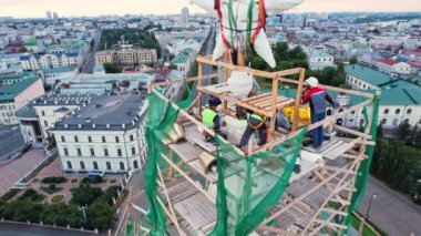 ALMATY, KAZAKHSTAN - 13 AĞUSTOS 2023: Çalışan ekip binanın tepesine yıldız kurma sürecine dahil oldu. İnşaat süreci şehirdeki yüksek binanın çatısında gerçekleşiyor