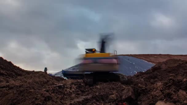 挖掘机在土堆上堆满了桶 工人们在多云的白天用机器从建筑工地的采石场上挖土 — 图库视频影像