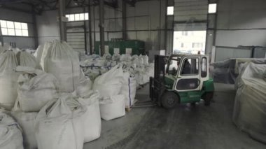 ALMATY, KAZAKHSTAN - EPTEMBER 06 2023: Forklift atölyeye gelir ve bölge fabrikasındaki bitmiş ürün deposuna gitmek için kimyasal gübre torbalarını toplar