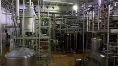 Beyaz cüppeli teknisyen kimyasal üretim atölyesinde yürüyor. Fabrikada çalışan kontrolü ve damıtma tankları