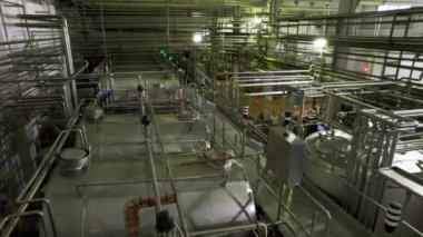 Fabrika atölyesinde kimyasallarla dolu büyük tankların yanındaki servis alanı. Boş köprü ve fabrikadaki işleme malzemeleriyle dolu büyük rezervler.