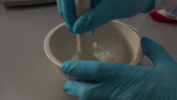 Laboratuvar Asistanı Yakın Çekimde Havanda Beyaz Taneli Madde Püresi Yapıyor — Stok video
