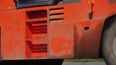 ALMATY, KAZAKHSTAN - 16 AĞUSTOS 2023: Paten kamyonu yol boyunca yeni asfalt kaplamalı inşaat alanındaki araçlar. Sıkıştırıcı, otoyol yüzeyinde sıcak karışıma basıyor