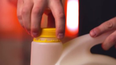 Adam film dekorasyonu için boya kutusunu büküyor. Erkek asistan film sahnesi için parlak arkaplan yaratmak için boya kullanır