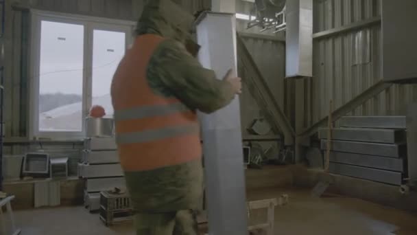 アルゼンチン カザフスタン October 2023 人間は ワークショップで建設するために金属ベントパイプを運ぶ 労働者は建設の近くで休むためにベントパイプを攻撃する 金属ベントパイプを接続する — ストック動画