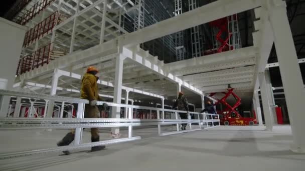 阿尔泰 哈萨克斯坦 2023年10月10日 工人们将长长的金属栏杆运送到货运电梯 工业园区仓库 男人们准备用货运电梯吊装金属栏杆 — 图库视频影像