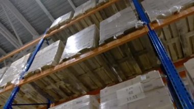 Depoda depolanmış paketler. Seri numaraları nakliyeye hazır. Endüstriyel parktaki depodaki ahşap raflarda duruyor.