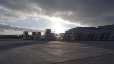 Endüstriyel park alanına yerleştirilmiş sayısız sandık. Gün batımında endüstriyel kompleksin sınırları içinde birden fazla konteynır bulunur.