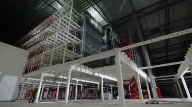 Malları dikey taşımak için endüstriyel yerleşke içinde yük-yolcu çekişi. İşçiler kargo-yolcu asansörünü kullanıyorlar.