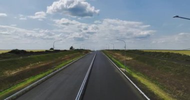 Şehir merkezinden çok uzakta tamamen yeni bir çift şeritli otoyol. Kullanıma hazır geniş kırsal alanlarla çevrili sokak lambaları olan uzun bir yol