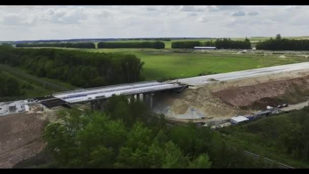 在铁路轨道上安装桥梁结构的第一阶段 准备在农村地区森林和田野地区铺设沥青路面的桥梁 — 图库视频影像