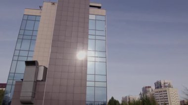 ALMATY, KAZAKHSTAN - 23 Eylül 2023: büyük çok katlı, cam pencereli ofis binası. Geniş, çok katlı ofis binası ön cephede cam paneller ve düz olmayan çatılarla donatılmış.