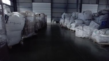 Depo barınakları hammaddeyle dolu geniş konteynırlar. Kimyasal gübre üretimi için yerleştirilmiş ikincil hammaddelerle dolu çuvallar