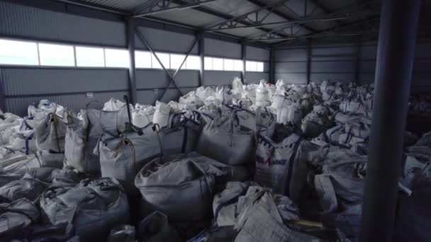 倉庫は建設用品で満たされた束の広い範囲を収容します 処理のために準備された資源で満たされた袋 — ストック動画