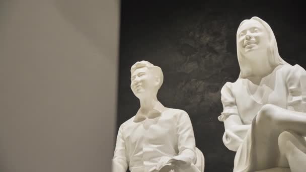 アルマニー カザフスタン February 2023 黒い背景に座っている若者の白い像 展覧会センターの観客グループによるアートコンポジション リアリスティック像 — ストック動画