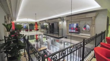 ALMATY, KAZAKHSTAN - 13 Şubat 2023: Parlak aydınlık modern kültür merkezinde metal çitlerle çevrili balkonlar. Dekorasyonlu çok katlı iş binasının muhteşem iç mekanı. Tiyatro salonu