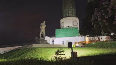 ALMATY, KAZAKHSTAN - 13 AĞUSTOS 2023: Spot ışıklarıyla gece gökyüzünün altında tamamlanmamış kule. İnsanoğlunun çimento figürü gecenin karanlığında kentsel kaleye bitişik duruyor.