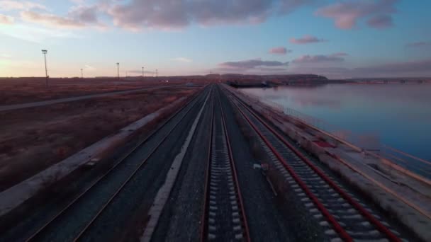 Longas Trilhas Ferroviárias Que Estendem Longo Rio Pôr Sol Área — Vídeo de Stock
