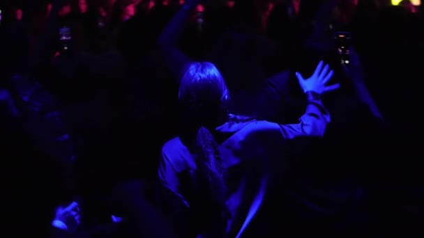 兴高采烈的女人带着长长的马尾辫跳舞 欣赏夜总会慢动作中的音乐 摇滚音乐会的观众听乐队演奏很开心 — 图库视频影像