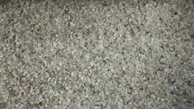 Plastic granules pouring on pile in recycling plant workshop closeup. Raw material for polymer items manufacturing in factory shop