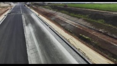 Kırsal kesimlerde asfalt ve yol işaretleri olan gelecek otoyol şeritleri. İnşaat alanının hava görüntüsünde çağdaş çevre yolu bakımı