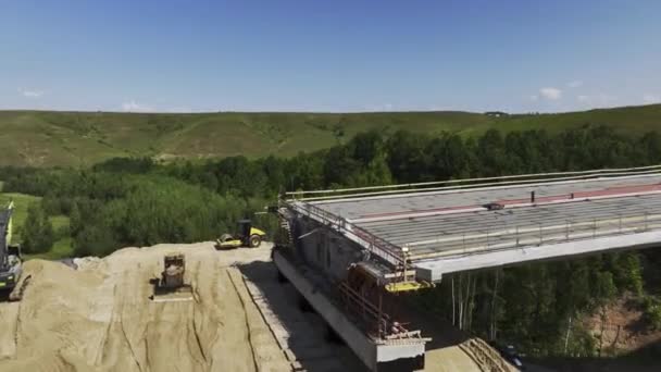 グリーンヒリー渓谷の将来の輸送橋断片 道路建設現場の空中ビューで組み立てられた交通過剰道路セクション — ストック動画