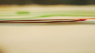 Yetenekli ressam parlak yeşil ve turuncu renkler kullanarak resim oluşturur. Kişi beyaz tuvale büyük harflerle yazmaya başlar.