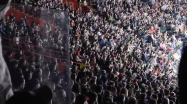 Heyecanlı seyirciler, bulaşıcı müzik ritmine göre dans ediyorlar. Konsere gidenler unutulmaz bir müzik gecesi için toplanıyor.