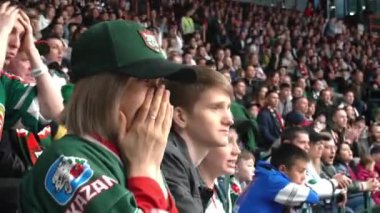 ALMATY, KAZAKHSTAN - 22 Aralık 2023: bayan taraftar samimi endişe ile hokey takımı için destek göstermektedir. Saygıdeğer takım kadınlarının giydiği giyinmiş stadyum tribünündeki taraftarlar arasında oturuyor.