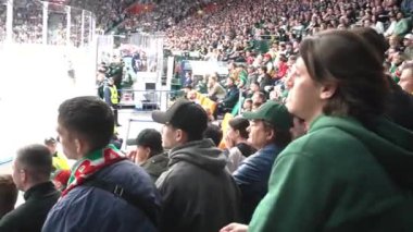 ALMATY, KAZAKHSTAN - 22 ARALIK 2023: Taraftarlar hokey maçı sırasında tribünde oturarak maçı tartıştılar. Ulusal hokey şampiyonasını izlemek için koltuklarda oturan heyecanlı izleyiciler