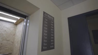 Asansörün yanına yerleştirilmiş konut binasında gezinme için tabela. Modern gökdelendeki ev sakinleri ve misafirler için seyrüsefer çözümü