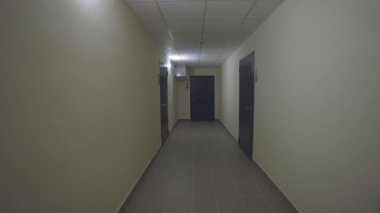 Konut binasında apartman kapısı olan uzun bir salon. Zemin, acil çıkışla güvenliği sağlar ve rahat bir deneyim için kaldırır.