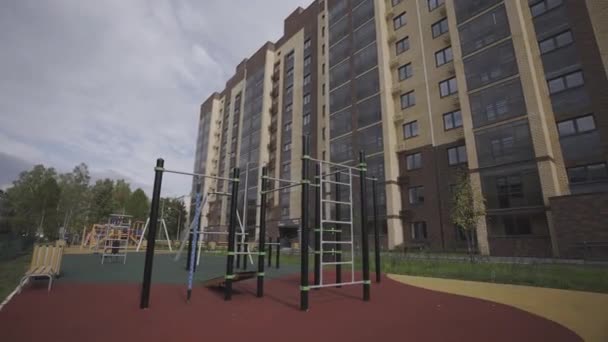 エリート住宅エリアの高層ビル近くの近代的な設備を備えた運動場 アスリートと子供のための遊び場が付いている住宅複合体 — ストック動画