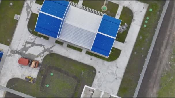 現代の排水処理プラントは 領土の砂床とトラックを備えています フィールド間のフェンスに囲まれた青いファサードの工業ビル — ストック動画