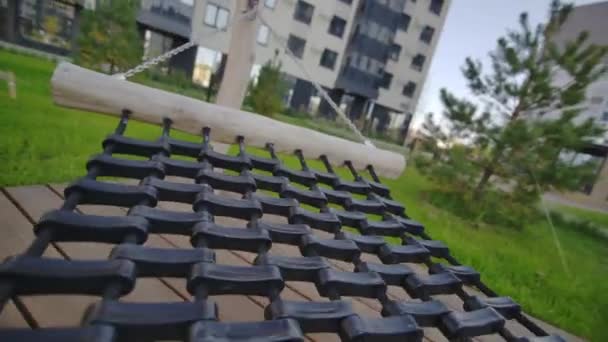 ゴム製ハンモックはアパートの建物の中庭にあり 太陽の下でリラックスできます リラクゼーションのための快適なものを備えた住宅エリア — ストック動画