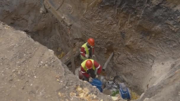阿尔泰 哈萨克斯坦 2023年8月24日 管道工在深坑的断管上放置了重金属细节 战壕中统一更换下水道系统元件的工人 维修工作 — 图库视频影像