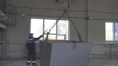ALMATY, KAZAKHSTAN - 26 AĞUSTOS 2023: İşçi endüstriyel fabrikada dev bir mekanik kova çalıştırıyor. Yeni fabrikada ağır metal ve nesneleri taşımak için teknolojik yardım