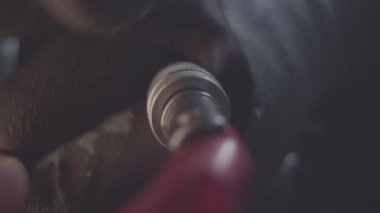 İşçi inşaat alanındaki kabloları birbirine bağlamak için metal parçaları teker teker büker. Çalışan atölyedeki kabloları adaptörle bağlar